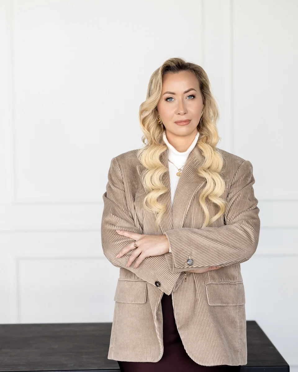 Žana su rudu švarku prie darbo stalo